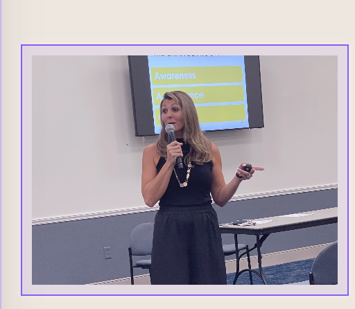 Lisa Rowe speaking into a microphone during a training presentation